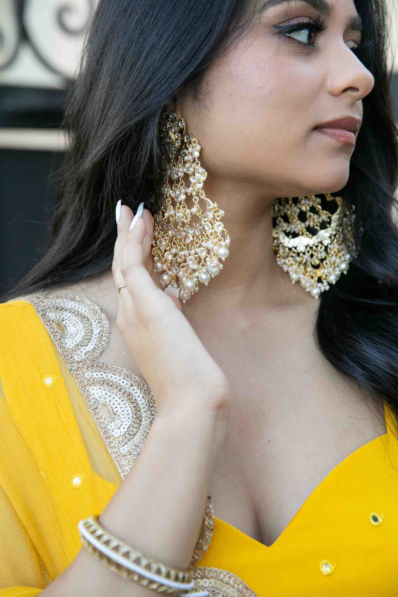 Model wearing Navya earrings: kundan - Romikas